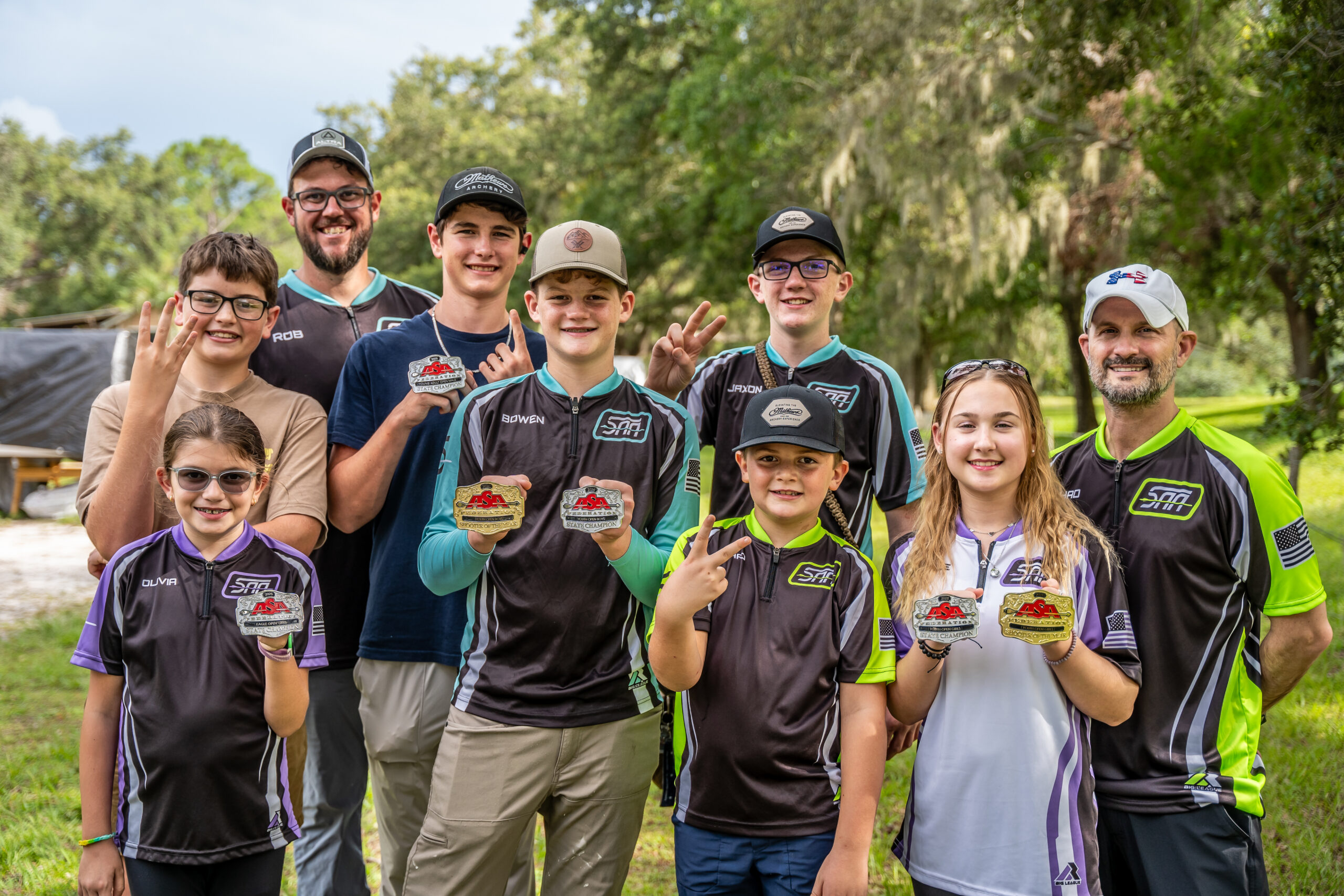 Youth archery team from Archery Sarasota displaying ASA State Championship belt buckles in Sarasota, FL